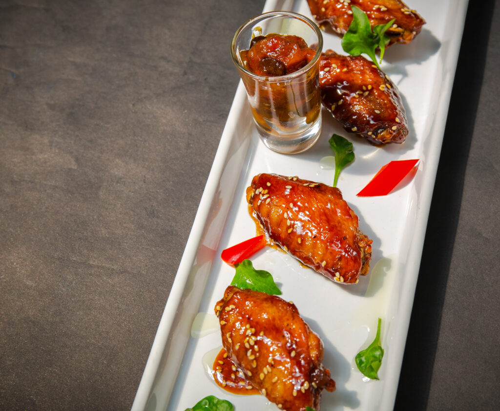 Saucy chicken wings, sticky wing sauce, coating sauce on chicken wings, buffalo wing sauce tips